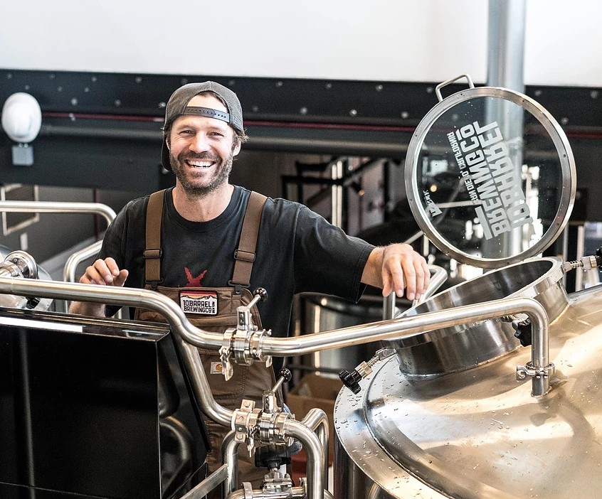 brewer mixing beer in a copper vat