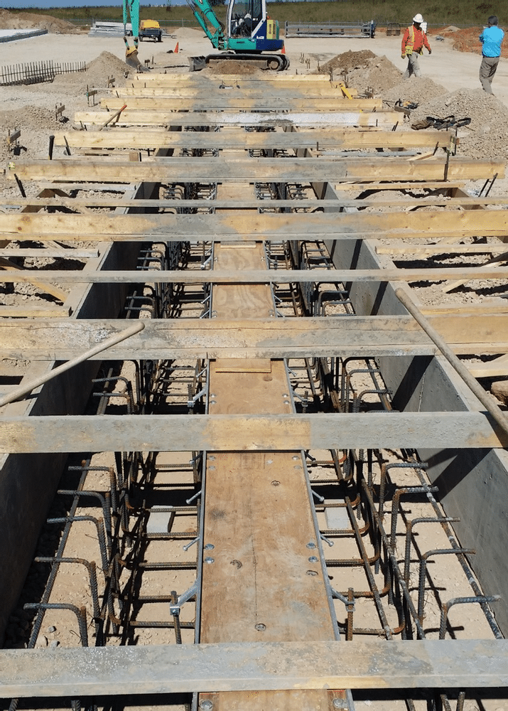 Plywood in top of trench drain is used to brace the channel drain.