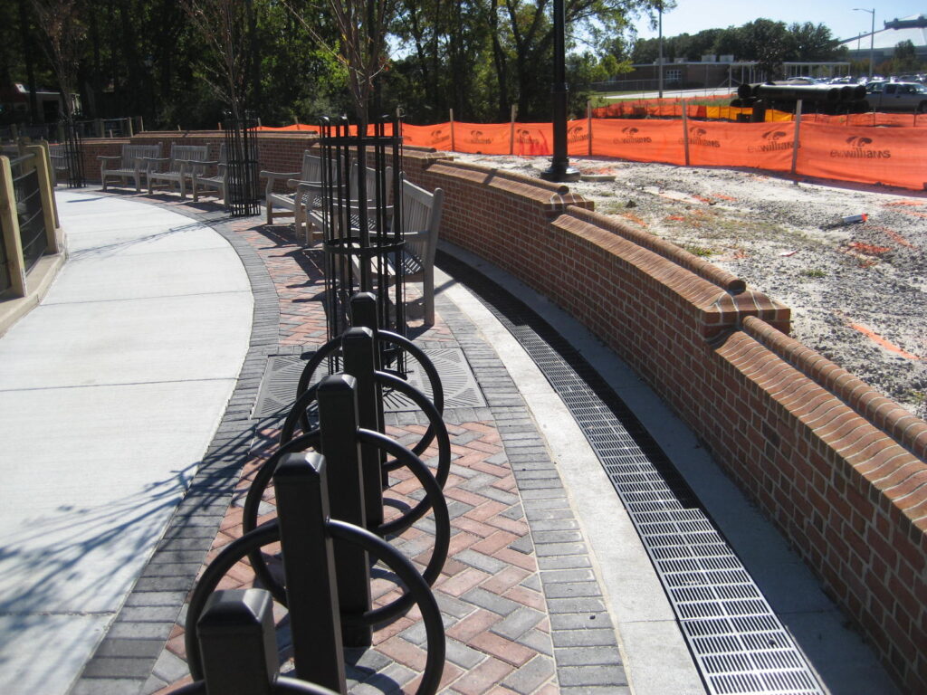 Trench drain in park next to brick wall